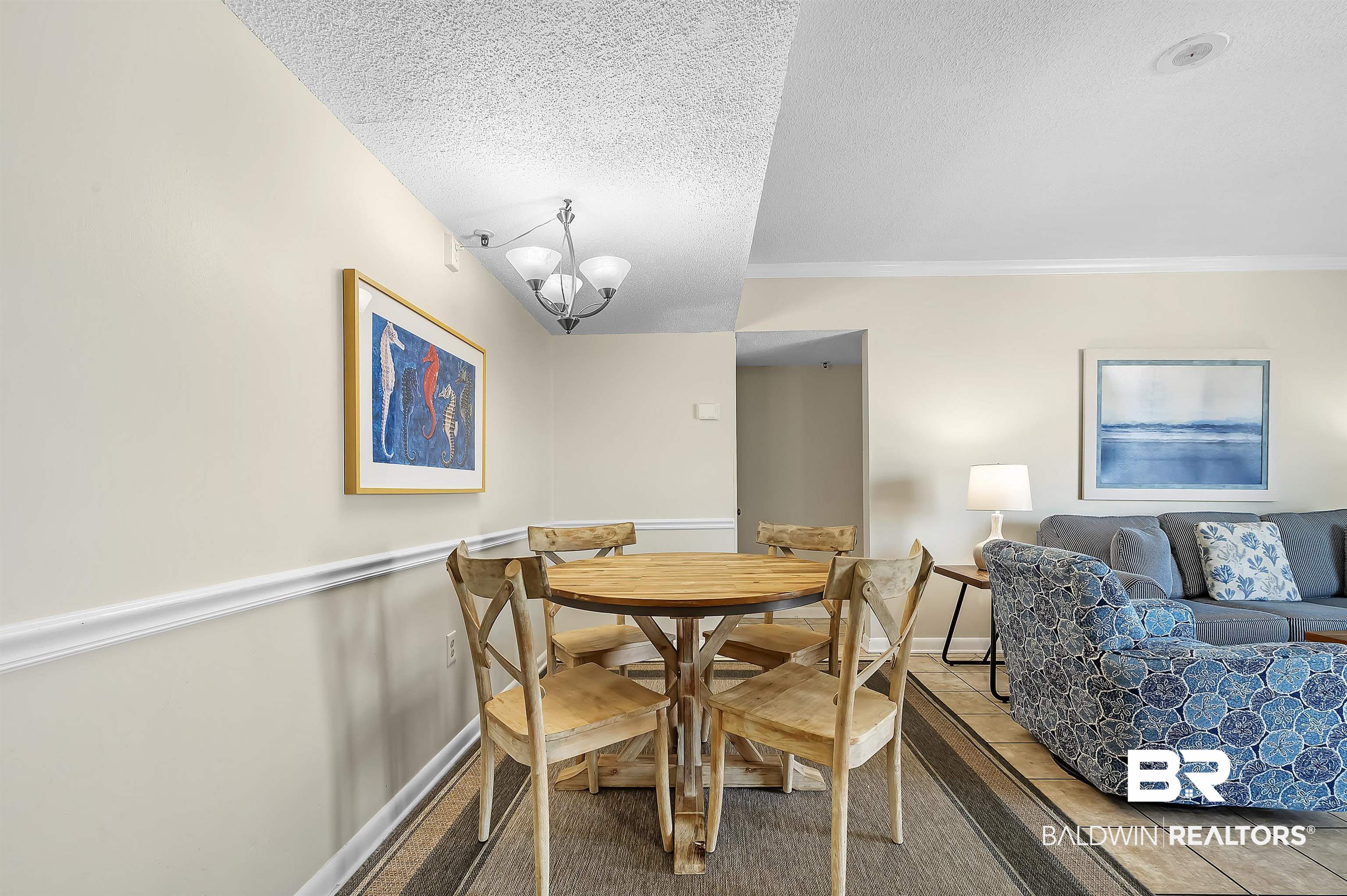 375 Plantation Road, Unit 5409 Gulf Shores, AL 36542 - Photo 8 of 48 Dining space featuring tile patterned flooring, an inviting chandelier, crown molding, and a textured ceiling