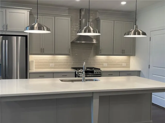 a kitchen with kitchen island a sink stainless steel appliances and cabinets