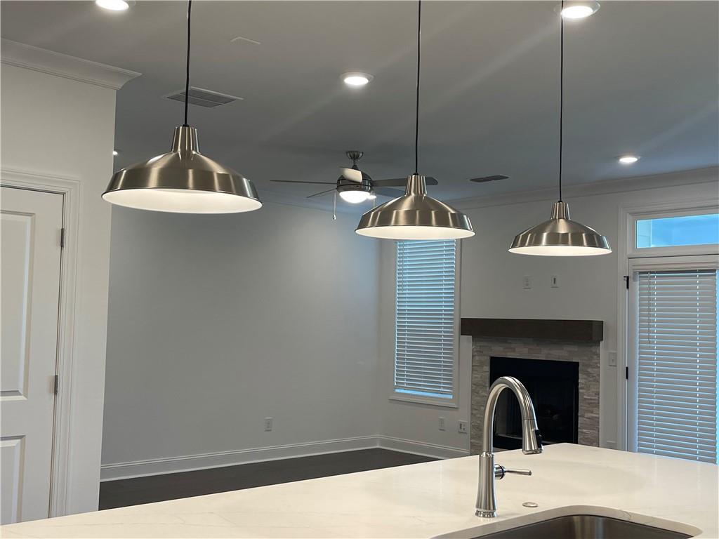 4807 Larkin Pass Buford, GA 30518 - Photo 24 of 58 a kitchen with a sink a chandelier and living room view