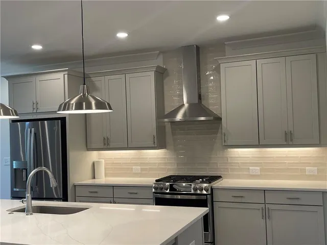 a kitchen with a sink a counter space appliances and cabinets
