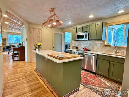 a kitchen with stainless steel appliances kitchen island granite countertop a sink and cabinets