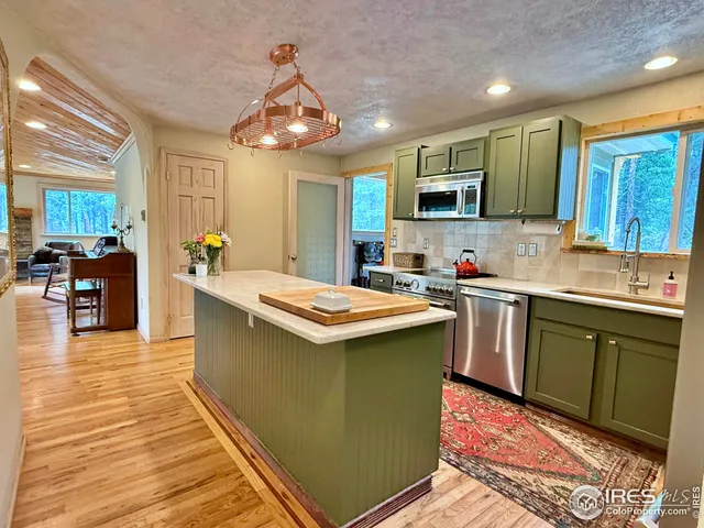 a kitchen with stainless steel appliances kitchen island granite countertop a sink and cabinets