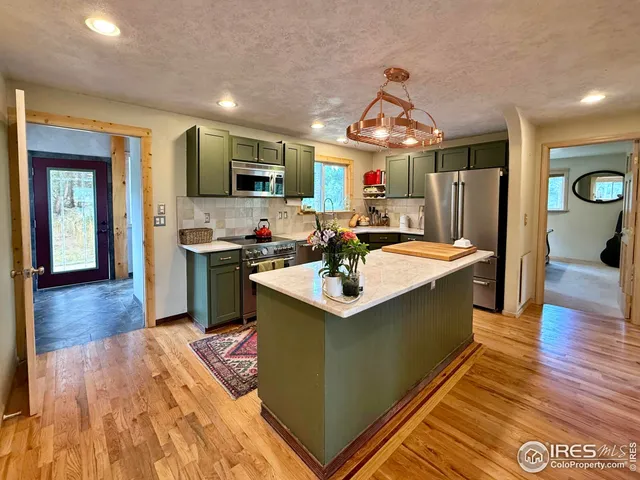 a kitchen with stainless steel appliances granite countertop a sink stove and wooden floor
