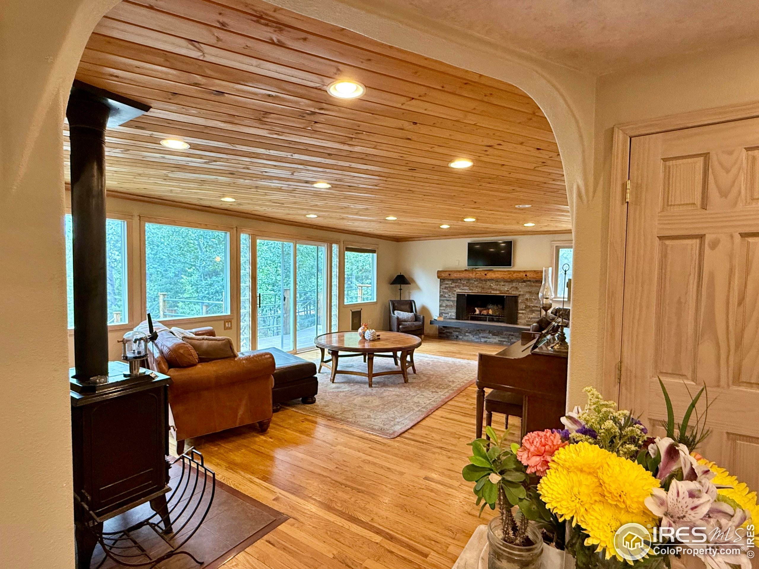 84 Ranch Road Ward, CO 80481 - Photo 7 of 45 a living room with fireplace furniture and a large window