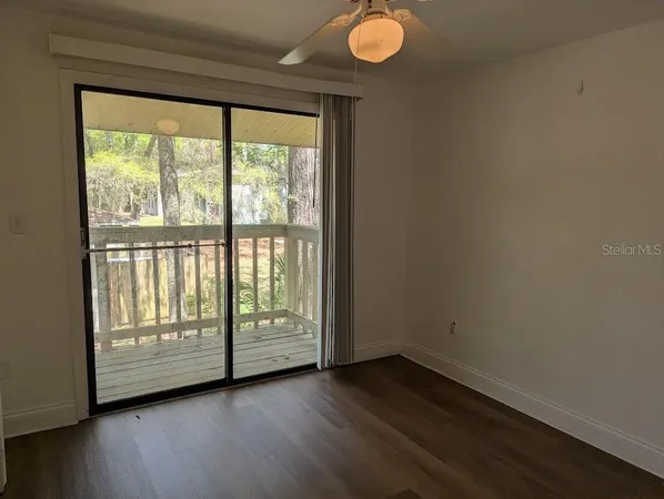 a view of an empty room with wooden floor and exposed radiator