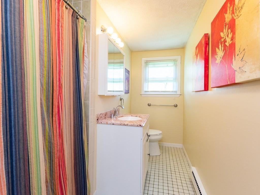 93 Graymore Road Waltham, MA 02451 - Photo 13 of 32 a bathroom with a sink a toilet and shower curtain