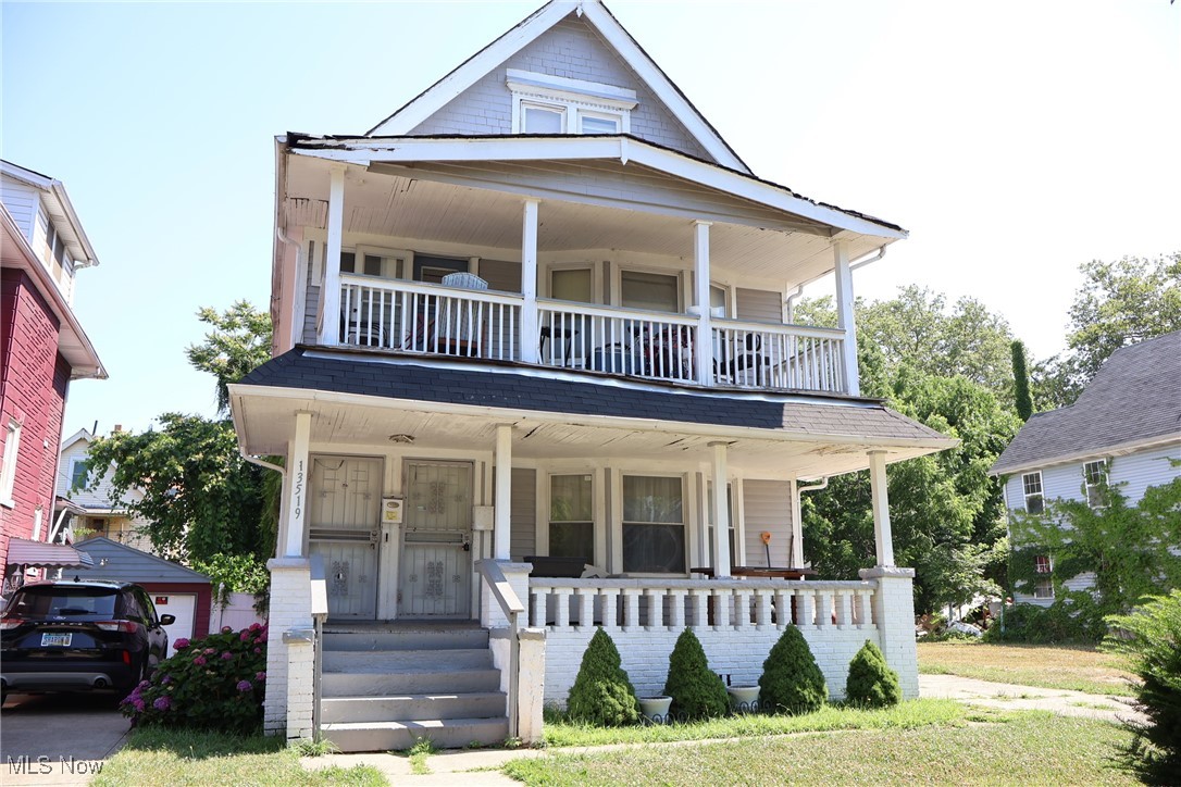 13519 Ashburton Road Cleveland, OH 44110 - Photo 1 of 12 View of front of property with covered porch, a balcony, and a garage