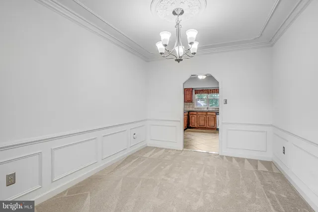 en empty room with wooden floor and chandelier