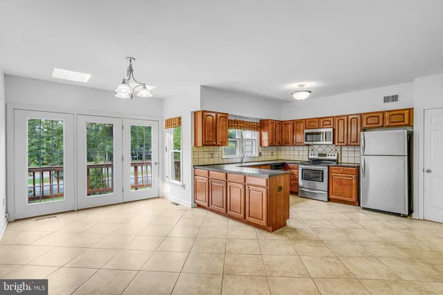 a large kitchen with a large counter top and stainless steel appliances