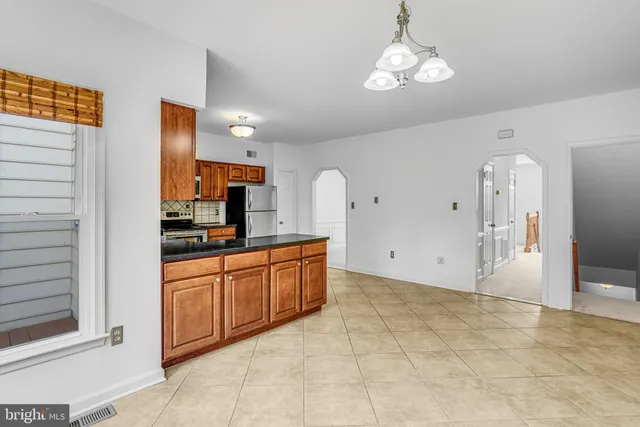 a large kitchen with stainless steel appliances granite countertop a stove and cabinets