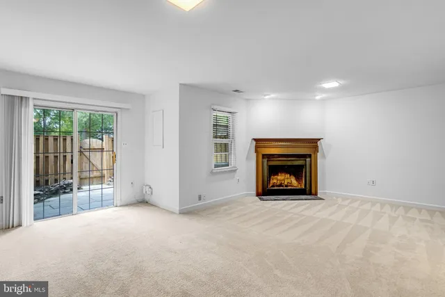 a view of an empty room with a fireplace and a window