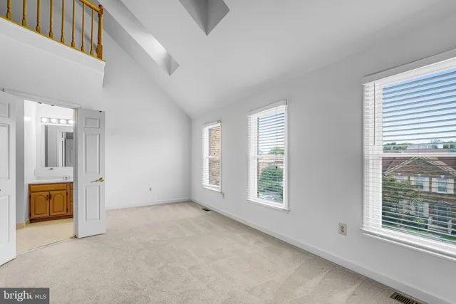 a view of an empty room with a window and a kitchen