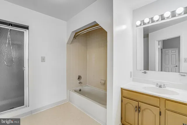 a bathroom with a tub sink and mirror