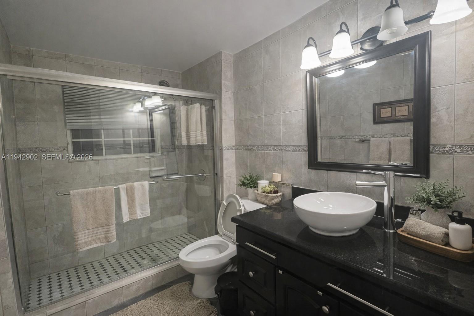 16276 Southwest 26th Street Miramar, FL 33027 - Photo 6 of 8 a bathroom with a granite countertop sink mirror vanity and toilet