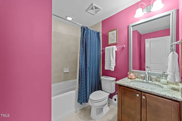 a bathroom with a granite countertop toilet sink and mirror