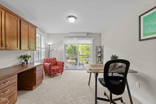 a view of a workspace room with furniture and windows