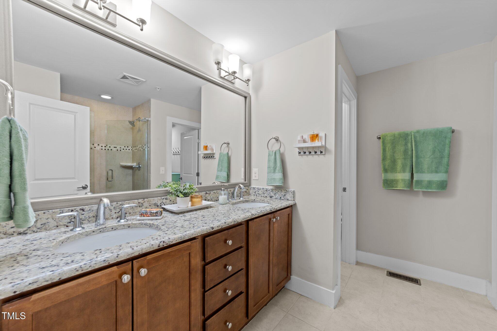 511 North Person Street, Unit 101 Raleigh, NC 27604 - Photo 23 of 35 a bathroom with a granite countertop double vanity sink and a mirror