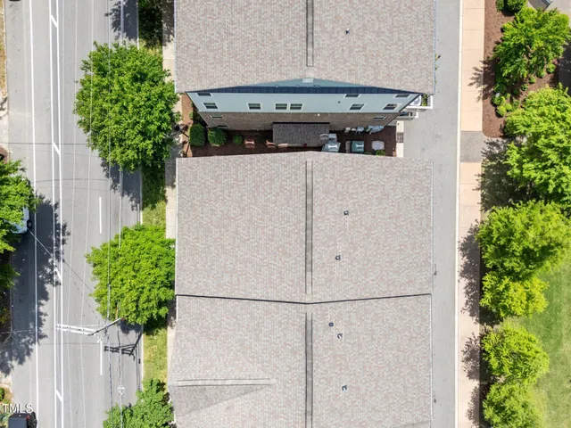 a white house with potted plants and a yard in back