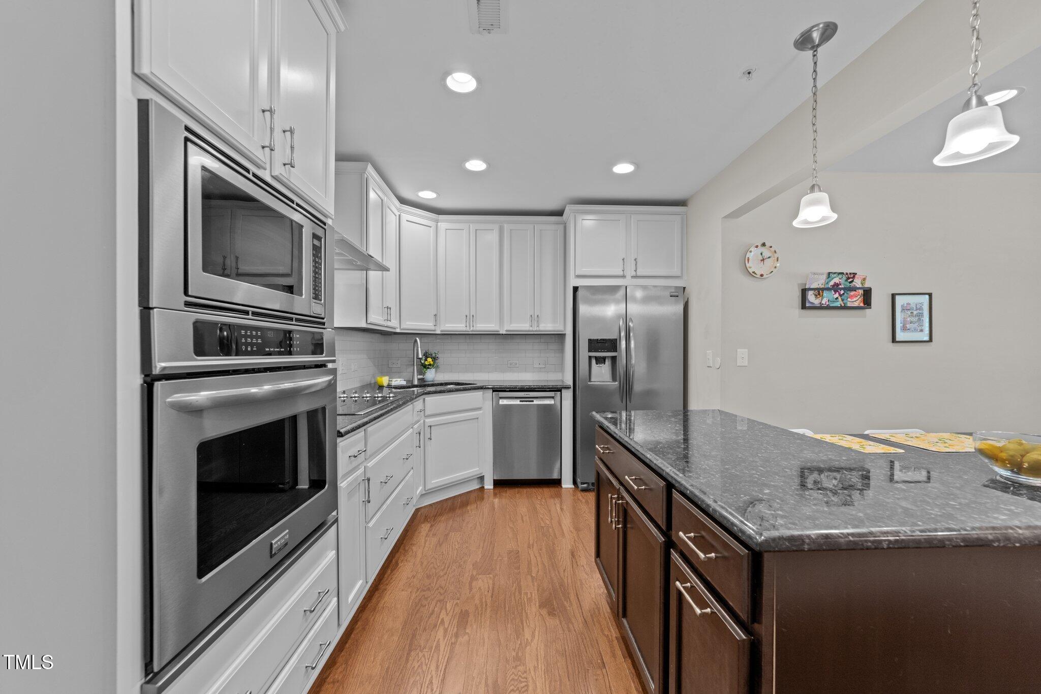 511 North Person Street, Unit 101 Raleigh, NC 27604 - Photo 8 of 35 a kitchen with granite countertop a refrigerator oven and a stove