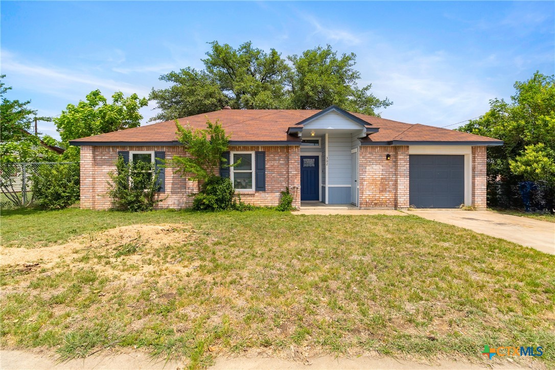 a front view of house with yard and trees around