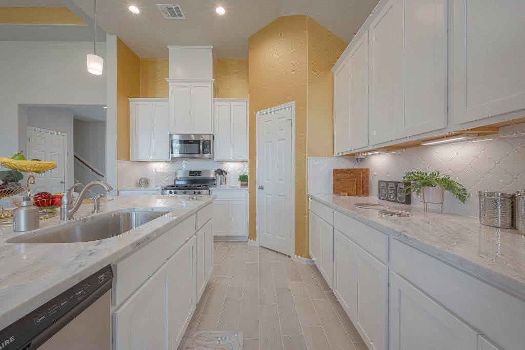 1061 Apple Ridge Road Magnolia, TX 77355 - Photo 15 of 49 a kitchen with stainless steel appliances a sink a stove and a refrigerator