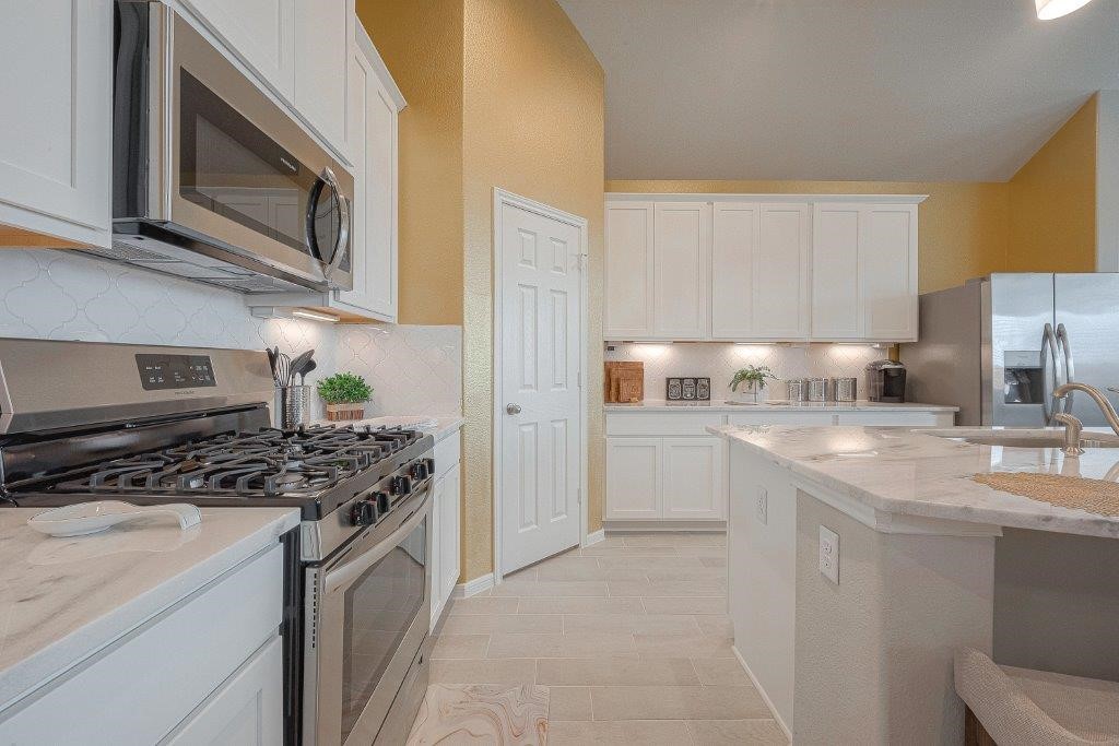 1061 Apple Ridge Road Magnolia, TX 77355 - Photo 19 of 49 a kitchen with stainless steel appliances granite countertop a stove top oven a sink dishwasher and a refrigerator with wooden cabinets