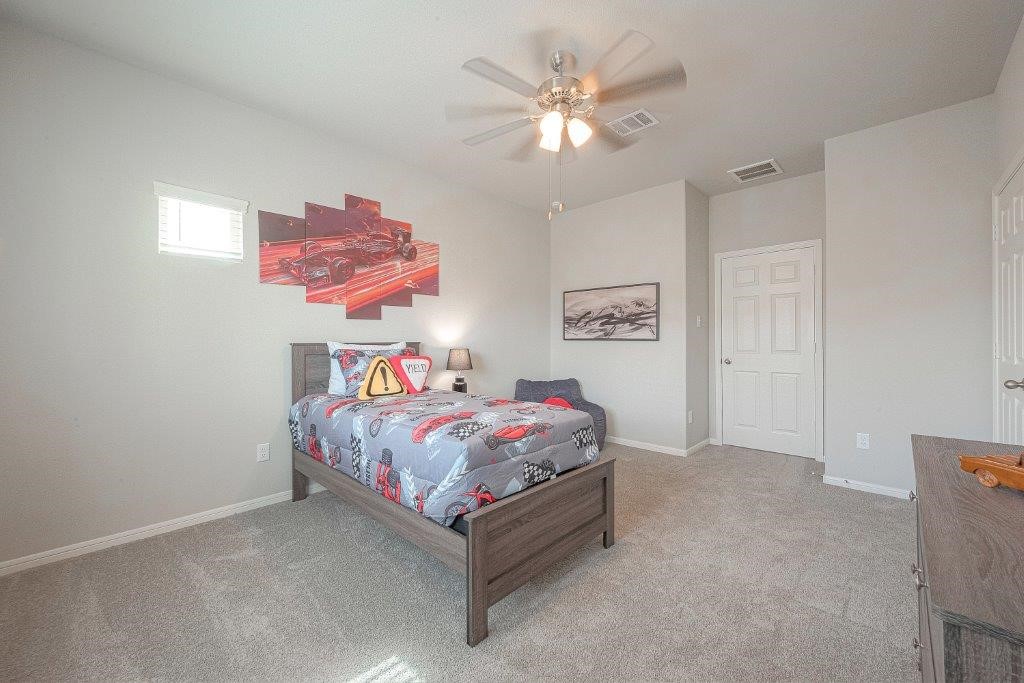 1061 Apple Ridge Road Magnolia, TX 77355 - Photo 32 of 49 a bedroom with a bed and a chandelier