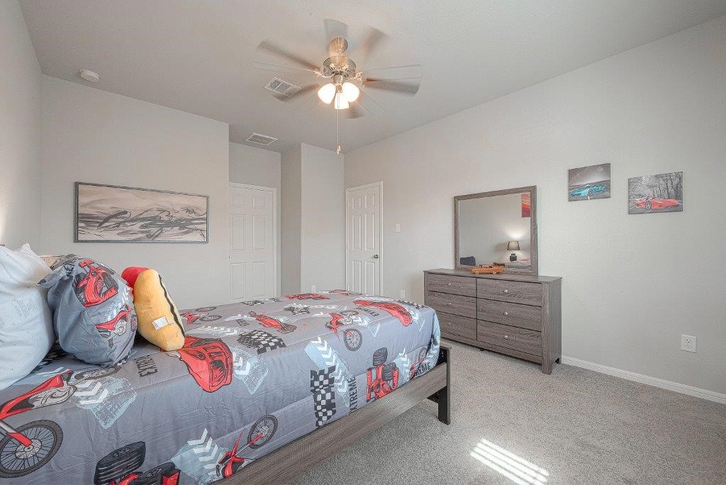 1061 Apple Ridge Road Magnolia, TX 77355 - Photo 33 of 49 a bedroom with a bed and a chandelier