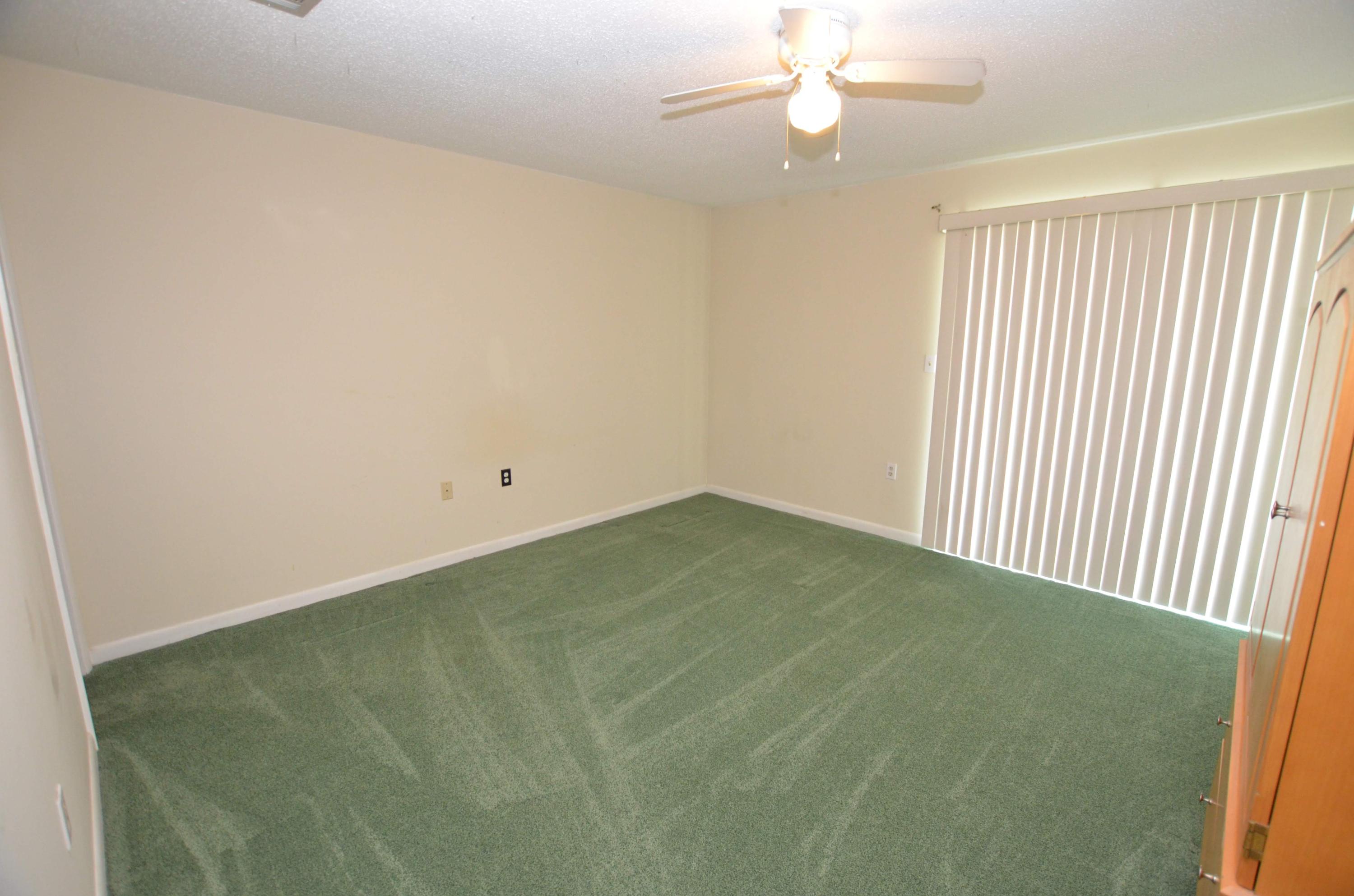 81 Cross Creek Road, Unit 22 Miramar Beach, FL 32550 - Photo 12 of 13 an empty room with a chandelier fan and windows