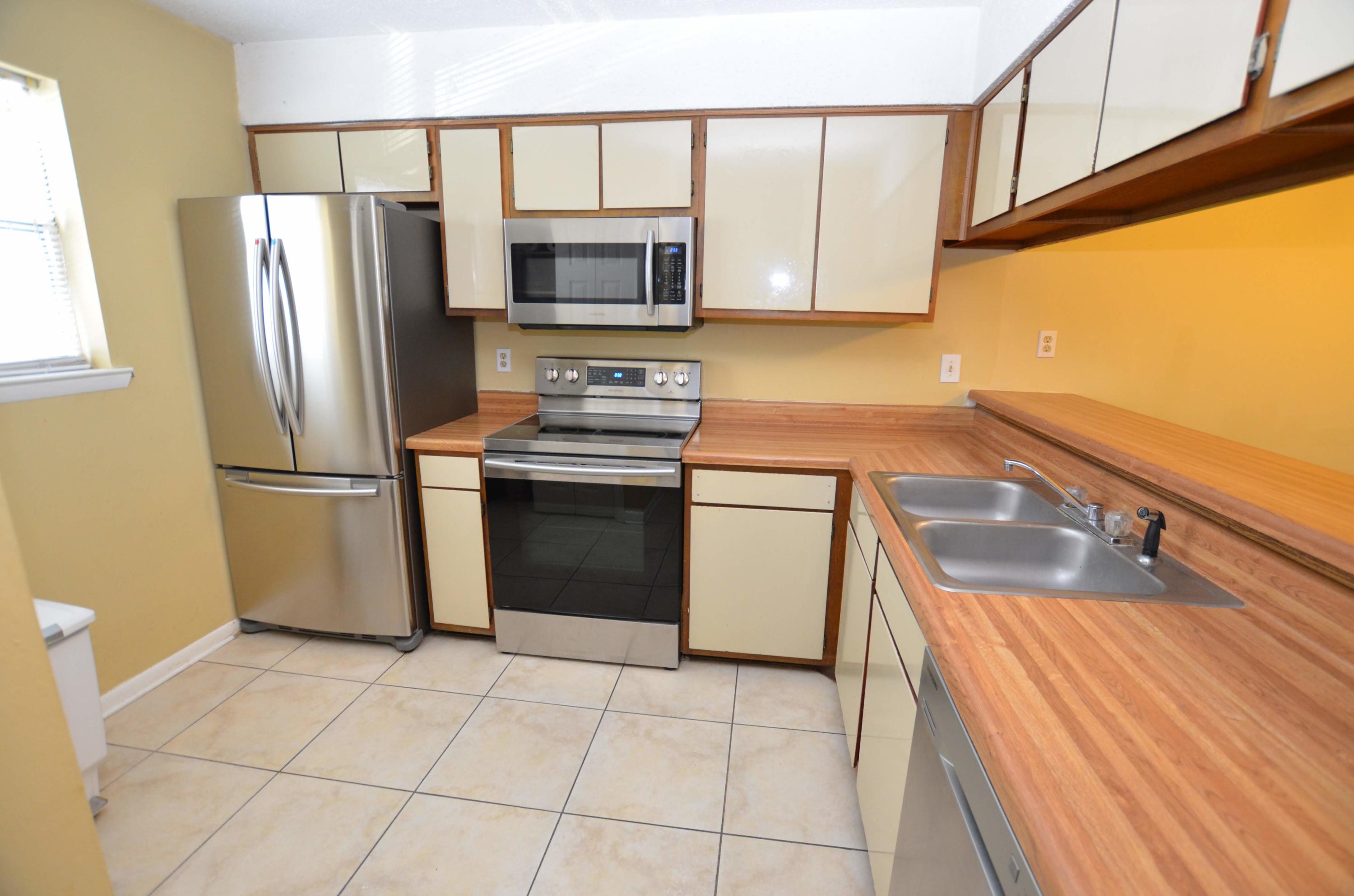 81 Cross Creek Road, Unit 22 Miramar Beach, FL 32550 - Photo 5 of 13 a kitchen with stainless steel appliances granite countertop a refrigerator sink and stove