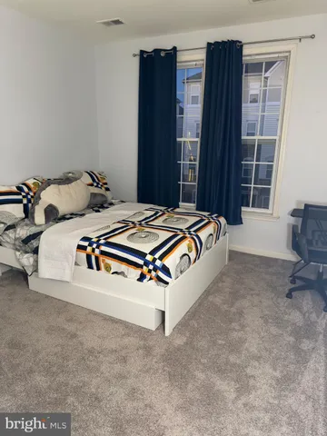 a bed sitting in a spacious bedroom next to a window