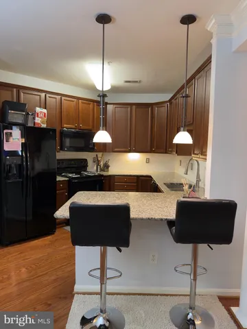a kitchen with stainless steel appliances kitchen island a refrigerator and a coffee table