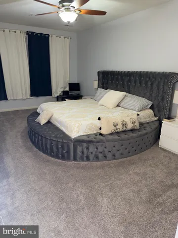 a bed sitting in a room and kitchen view