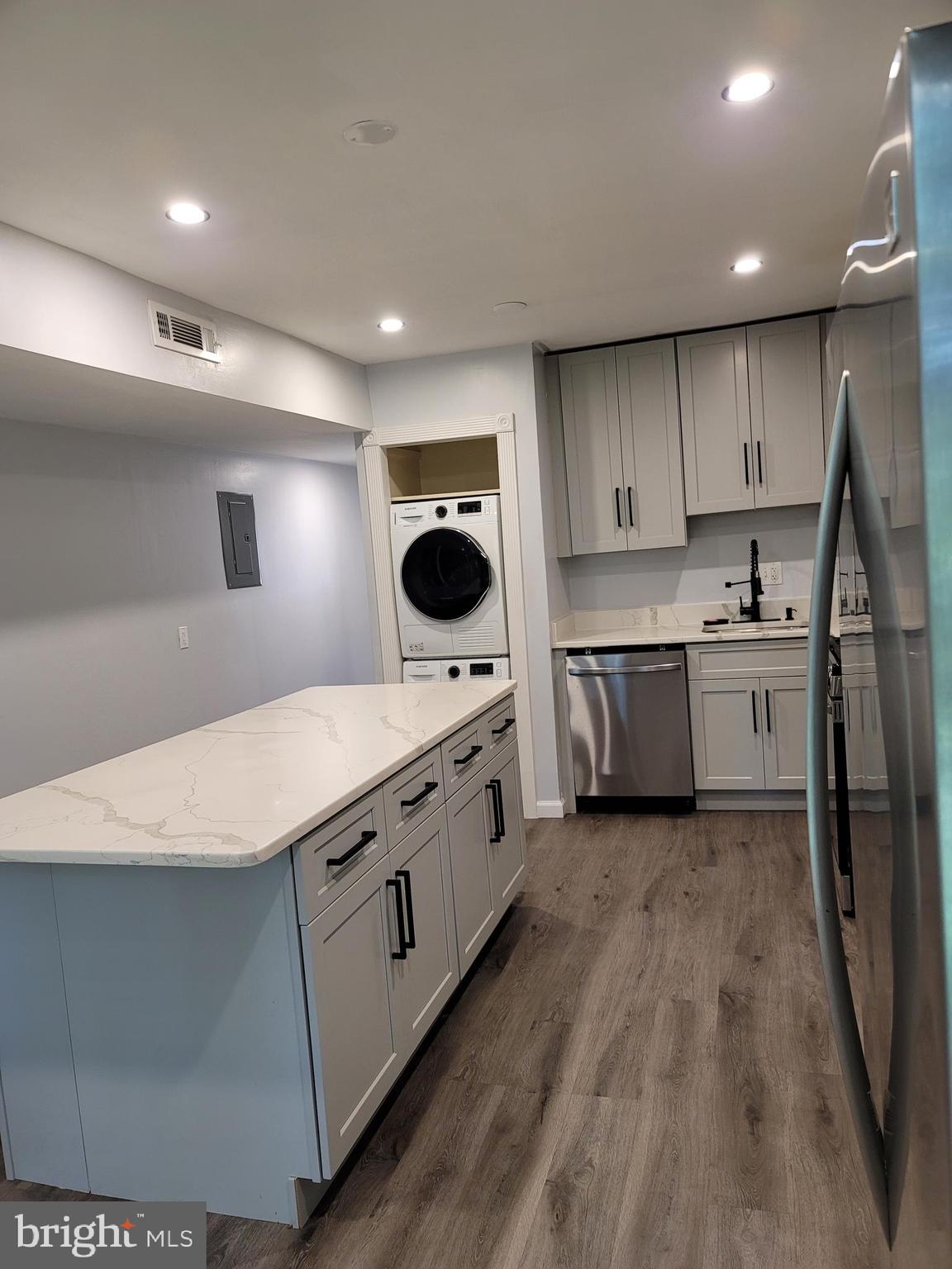 5049 7th Road South, Unit 201 Arlington, VA 22204 - Photo 11 of 45 a kitchen with stainless steel appliances a sink a stove a microwave a refrigerator a white cabinets and wooden floor
