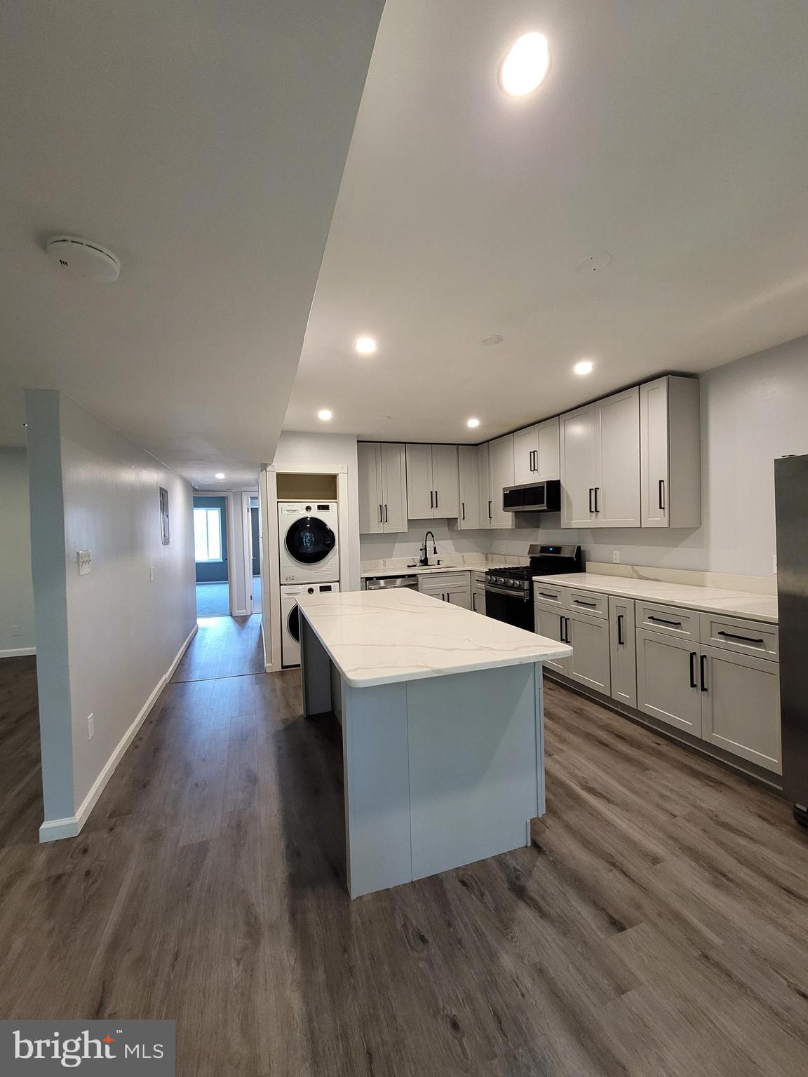 5049 7th Road South, Unit 201 Arlington, VA 22204 - Photo 13 of 45 a large white kitchen with wooden floors stainless steel appliances and view living room