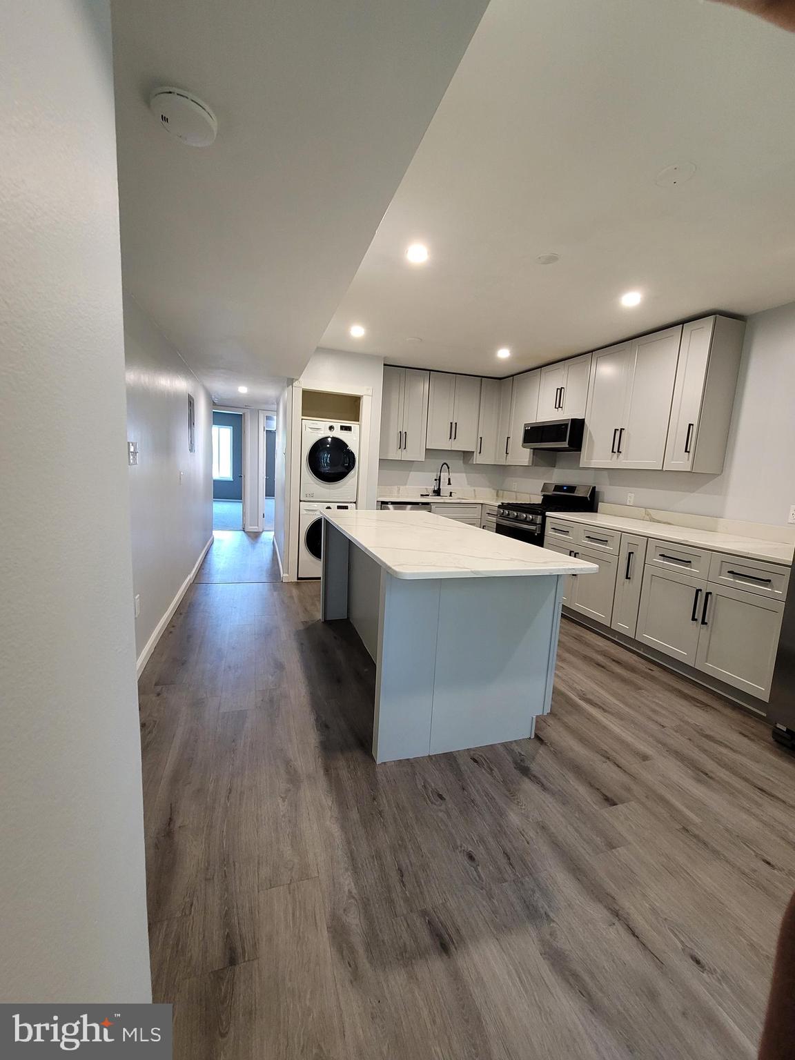 5049 7th Road South, Unit 201 Arlington, VA 22204 - Photo 14 of 45 a large white kitchen with wooden floors and view living room