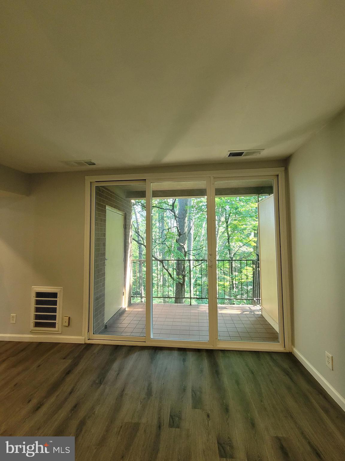 5049 7th Road South, Unit 201 Arlington, VA 22204 - Photo 7 of 45 a view of an empty room with wooden floor and a window