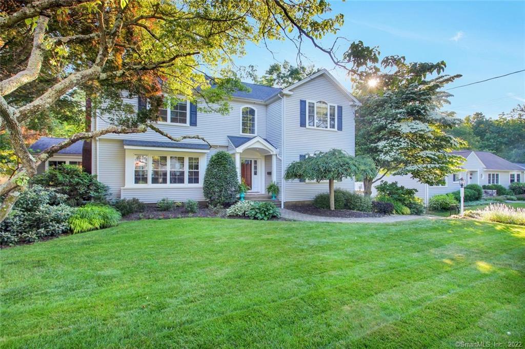 a front view of a house with a yard and green space
