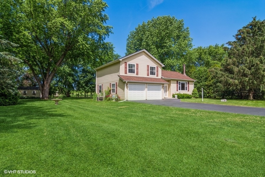 28 Jack Street Plano, IL 60545 - Photo 2 of 21 a front view of a house with a yard and trees