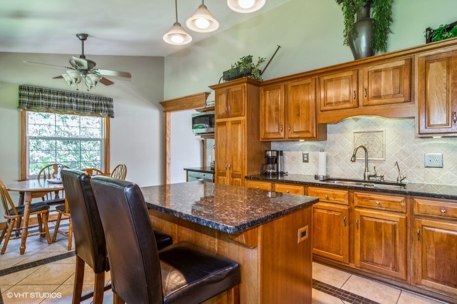 28 Jack Street Plano, IL 60545 - Photo 4 of 21 a view of kitchen island dining table and chairs