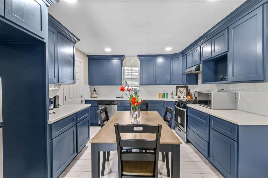10319 Old Seagoville Road Dallas, TX 75217 - Photo 11 of 14 a kitchen with kitchen island granite countertop stainless steel appliances cabinets a sink and a stove