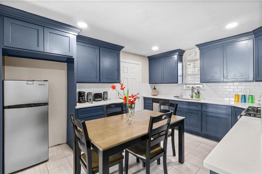 10319 Old Seagoville Road Dallas, TX 75217 - Photo 12 of 14 a kitchen with granite countertop a refrigerator a stove a sink dishwasher and wooden cabinets with wooden floor