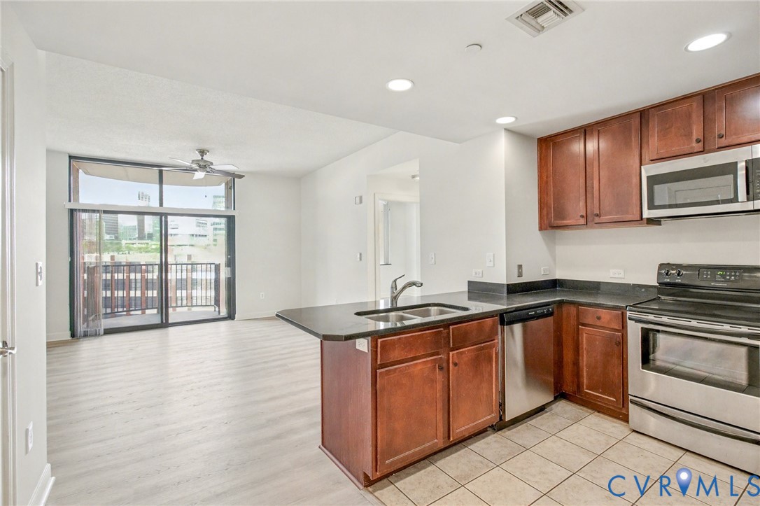 1101 Haxall Point, Unit U711 Richmond, VA 23219 - Photo 5 of 47 a kitchen with stainless steel appliances granite countertop a sink stove and cabinets