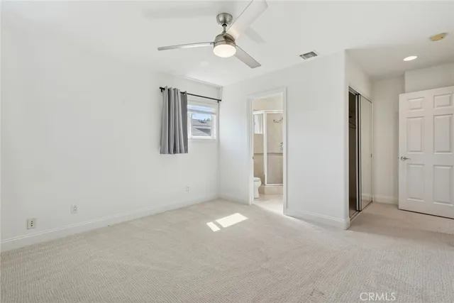 an empty room with closet and windows