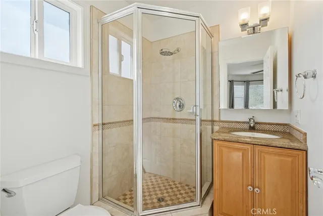 a bathroom with a granite countertop sink a mirror and shower