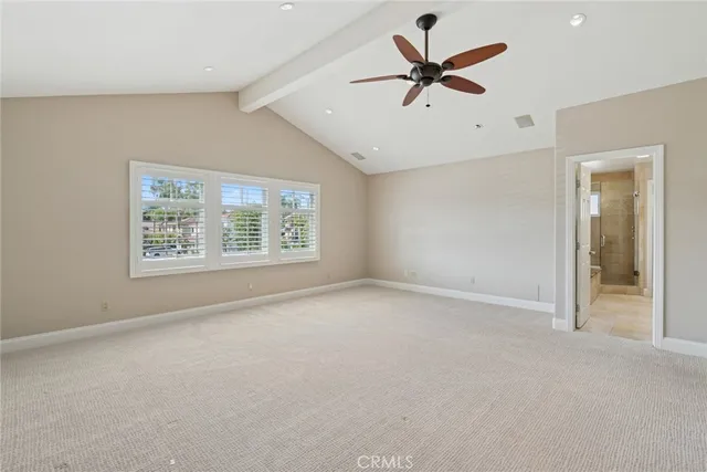 an empty room with ceiling fan and windows