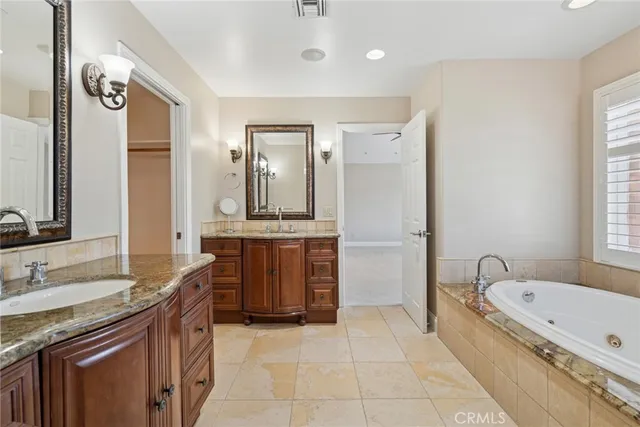 a spacious bathroom with a granite countertop tub sink and mirror