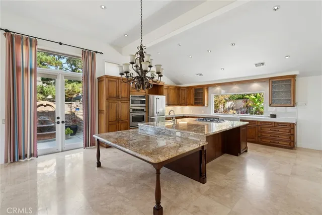 a large kitchen with kitchen island a large counter space and stainless steel appliances