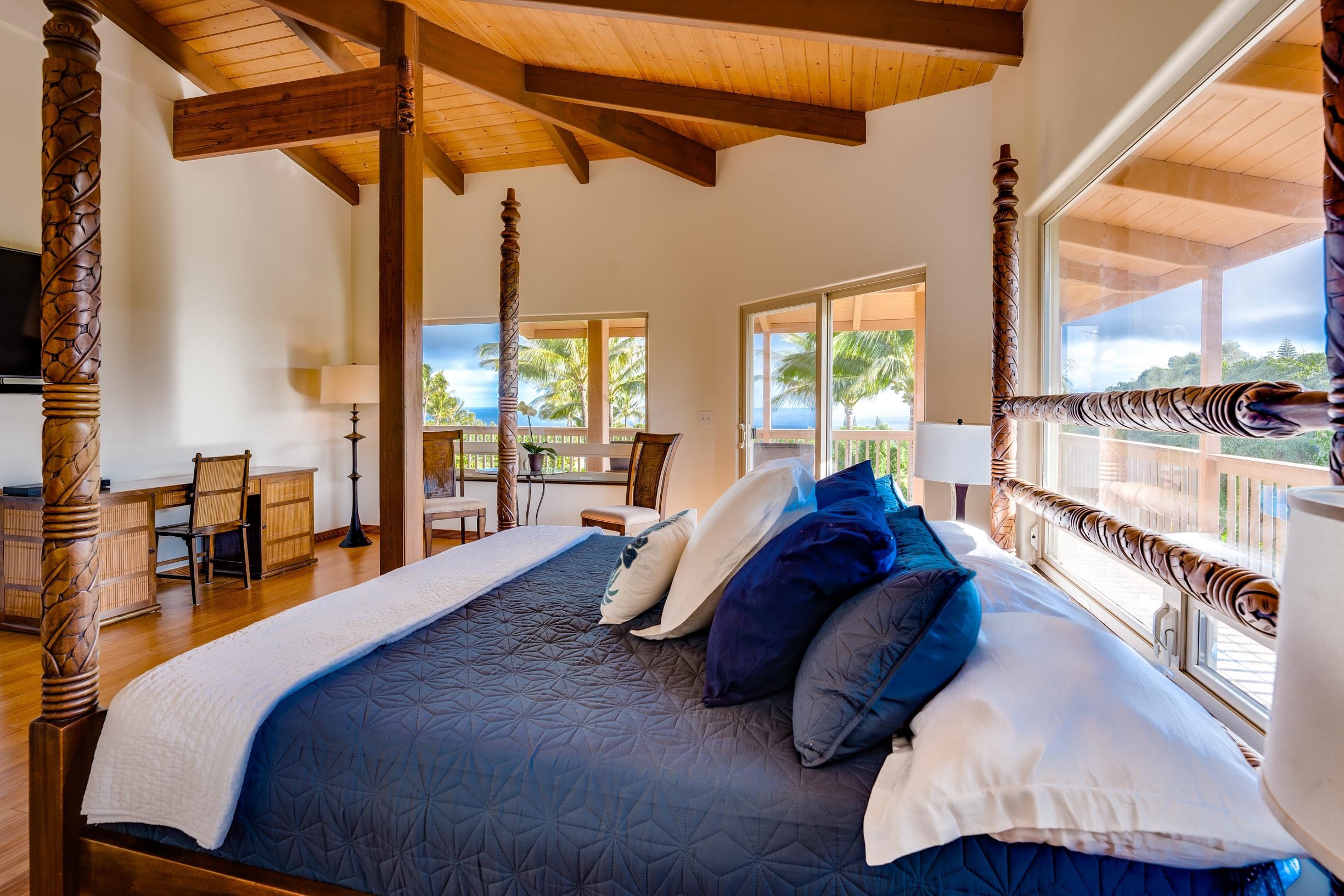 480 Puniawa Road Haiku, HI 96708 - Photo 16 of 30 a spacious bedroom with a bed and a large window