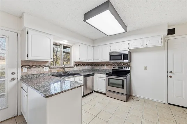 a kitchen with stainless steel appliances granite countertop a sink and cabinets
